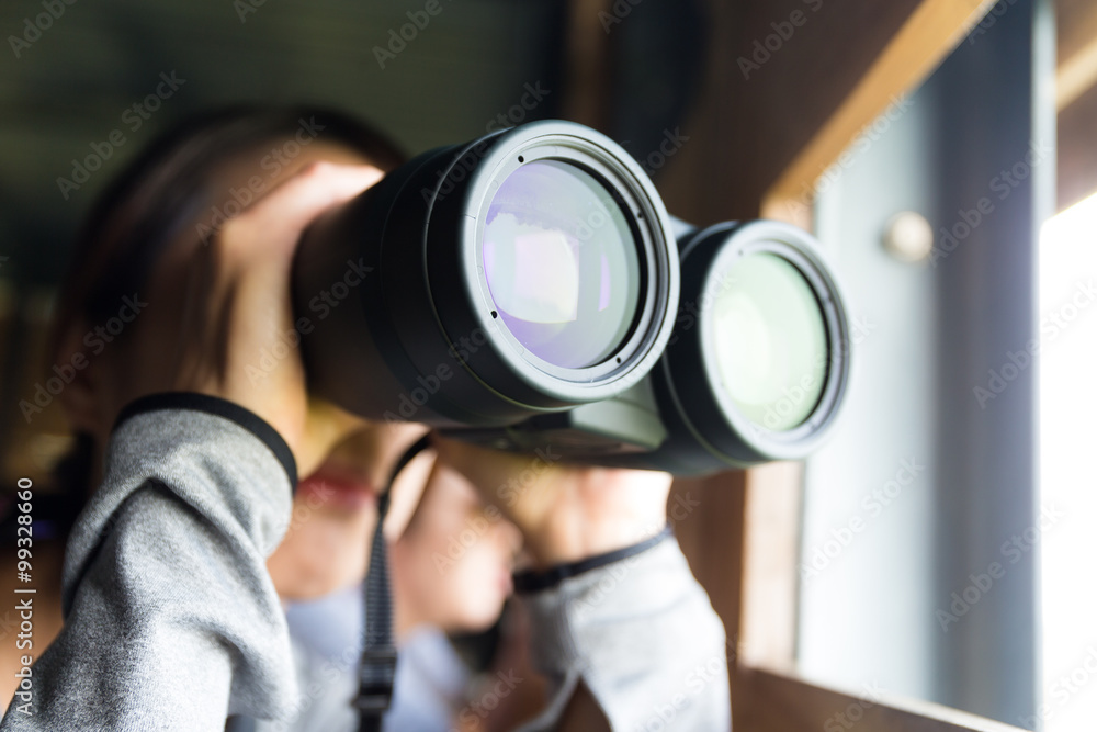 Asian Young woman use of the binocular for watching bird