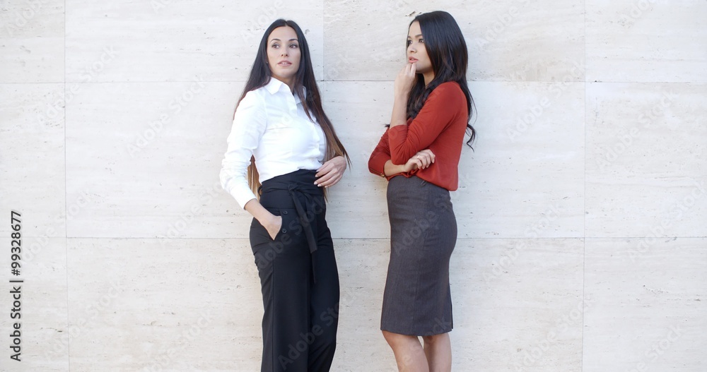 Two businesswomen standing chatting outdoors Two businesswomen standing chatting outdoors