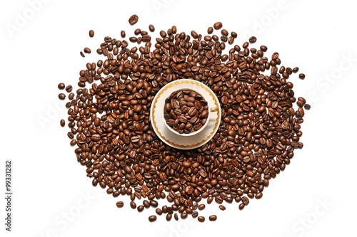  A cup of coffee and grains scattered on a white background