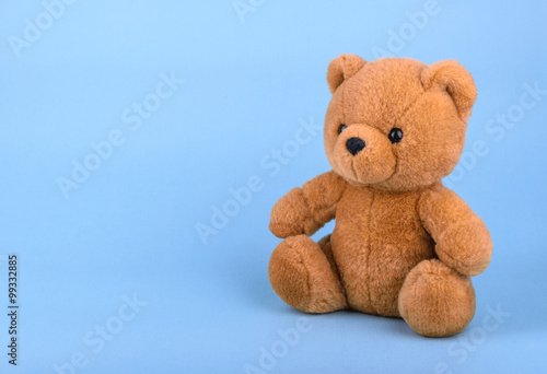 Toy teddy bear on blue background with copy space