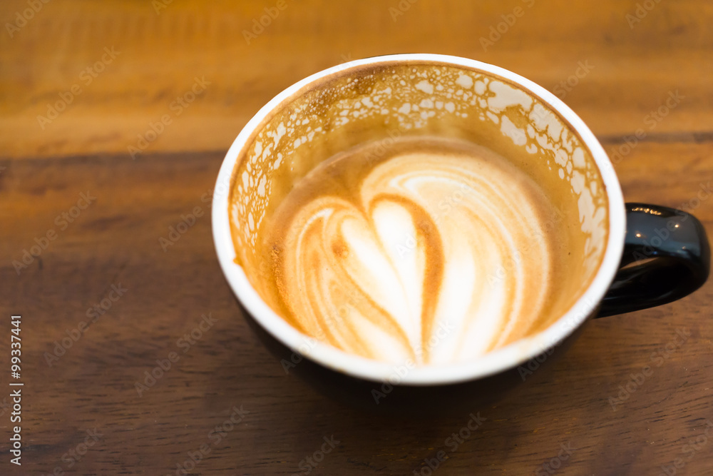 a cup of latte on wooden table