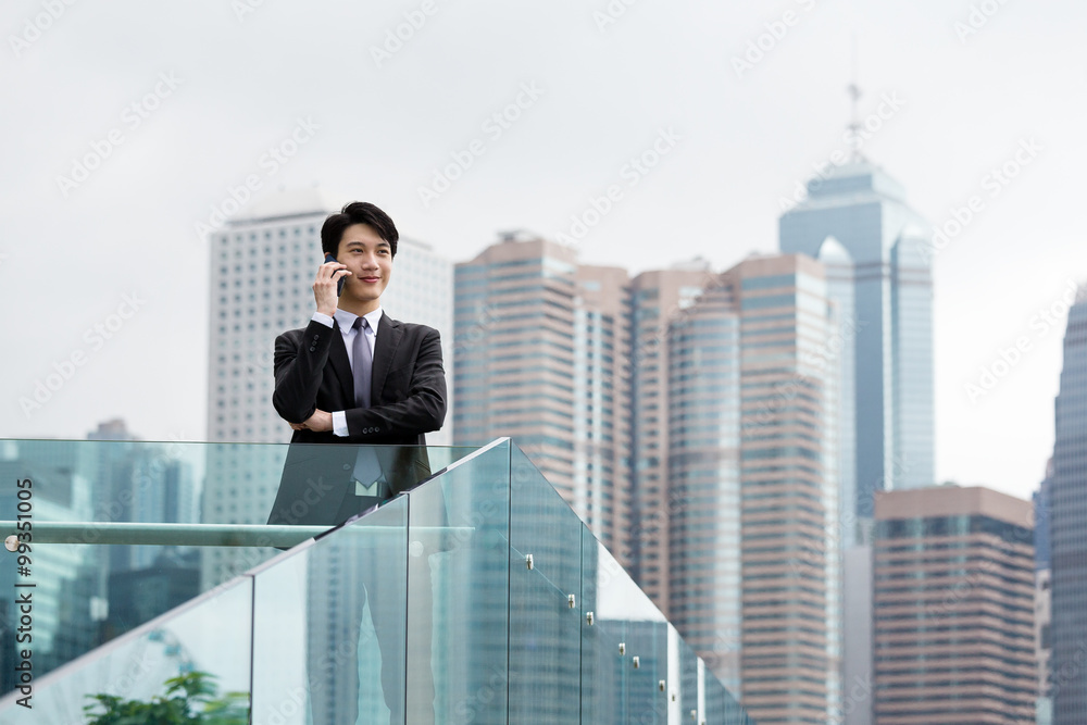 Young businessman talk to mobile phone at outdoor Young businessman talk to mobile phone at outdoor