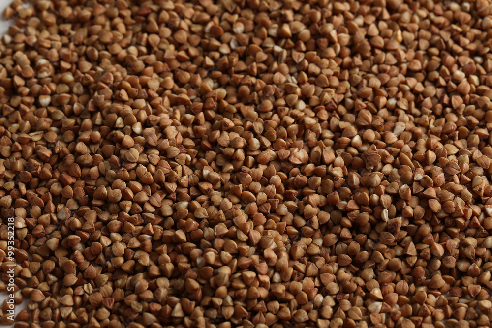 Pile of buckwheat seeds background, close up
