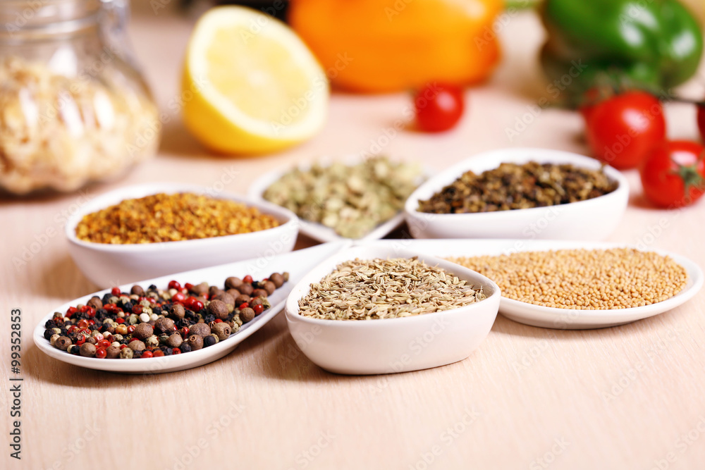 Variety of spices in ceramic containers on the kitchen table Variety of spices in ceramic containers on the kitchen table