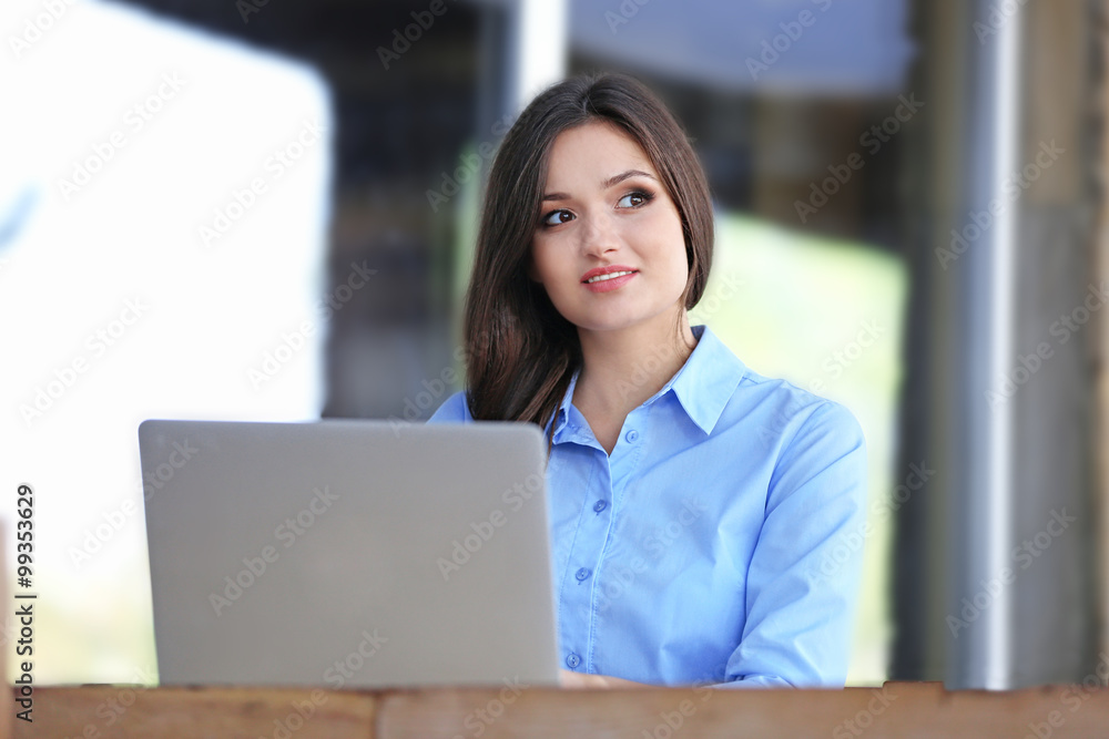 Young woman working with laptop in the office Young woman working with laptop in the office