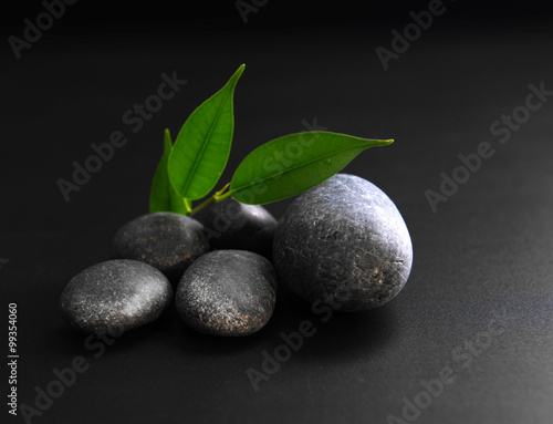 Pebbles with leaf on black background