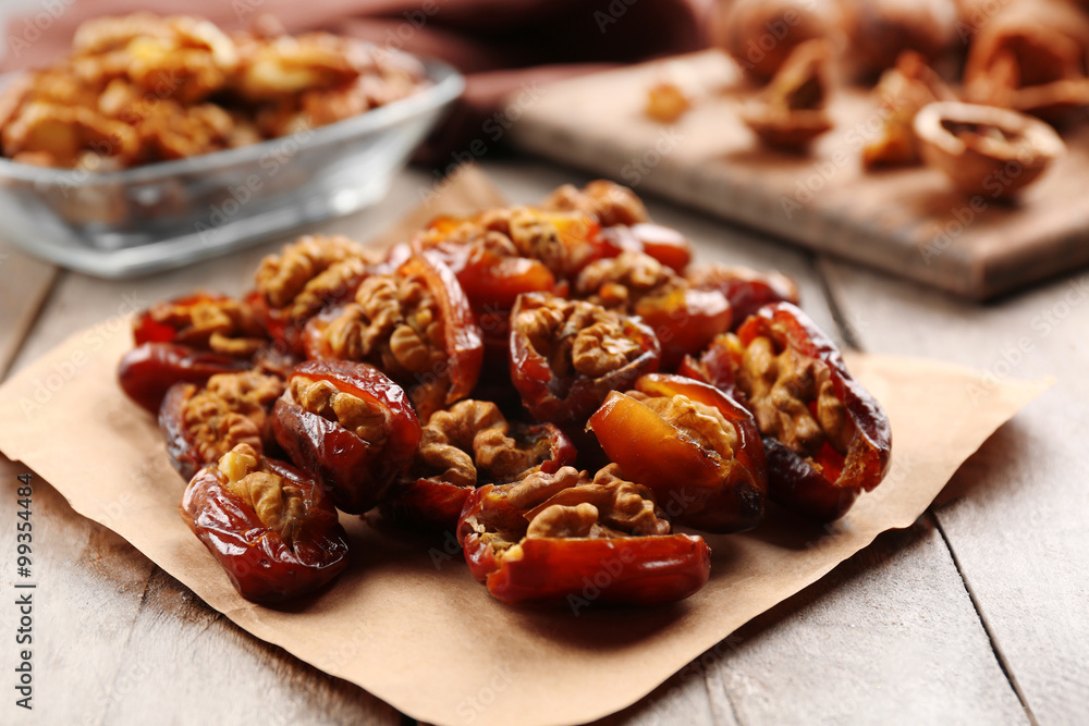 Walnut and date fruit on wooden table, close-up Walnut and date fruit on wooden table, close-up