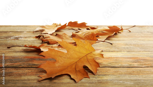 Yellow autumn leaves on wooden table  isolated on white