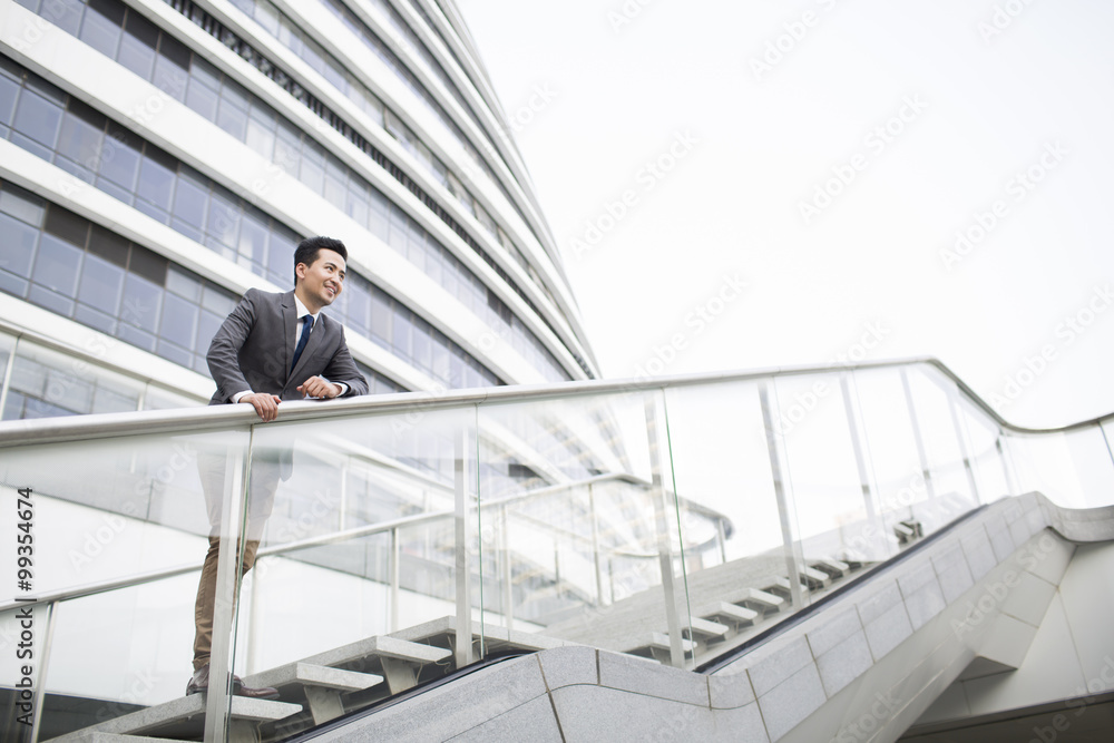 Businessman standing in front of office building Businessman standing in front of office building