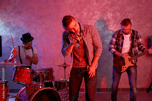 Musicians playing musical instruments and singing songs in a studio photo