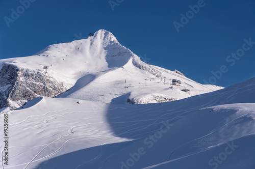 Hintertux Glacier, north summit of Gefrorenen-Wand-Spitzen, gondola cable cars, ski pistes and traces at sunset light. Hintertux ski resort in Zillertal Aps, Tirol, Austria