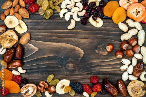 Mix of dried fruits and nuts on a dark wood background with copy space. Top view. Symbols of judaic holiday Tu Bishvat