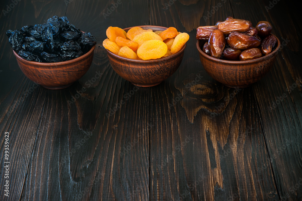Mix of dried fruits and nuts on dark wood background with copy space. Symbols of judaic holiday Tu Bishvat Mix of dried fruits and nuts on dark wood background with copy space. Symbols of judaic holiday Tu Bishvat