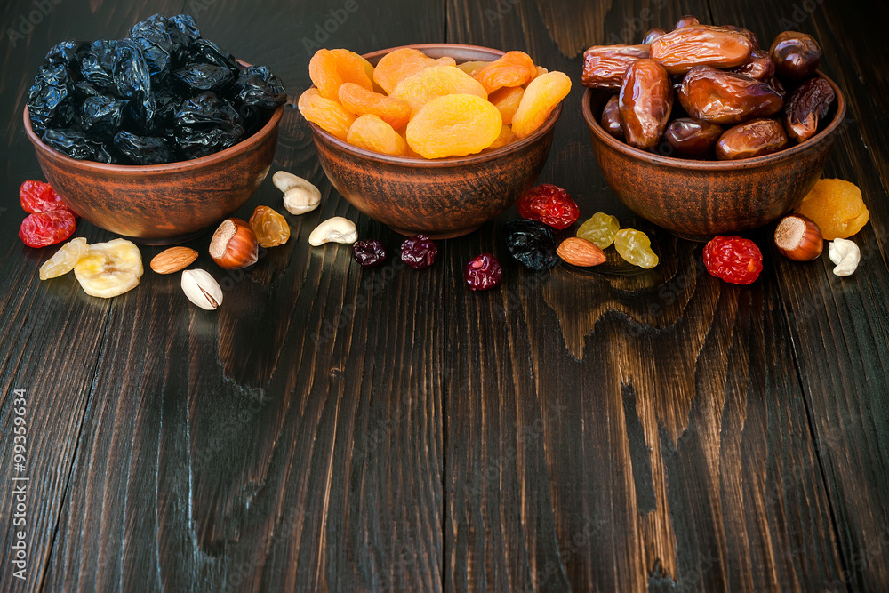 Mix of dried fruits and nuts on dark wood background with copy space. Symbols of judaic holiday Tu Bishvat Mix of dried fruits and nuts on dark wood background with copy space. Symbols of judaic holiday Tu Bishvat