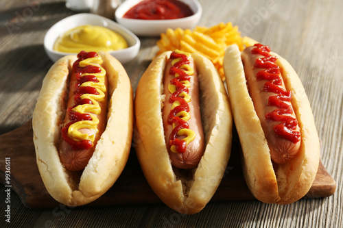 Tasty hot-dogs with chips on wooden background