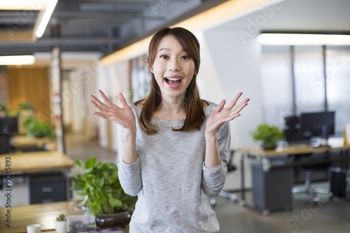 Young woman with surprised expression in office