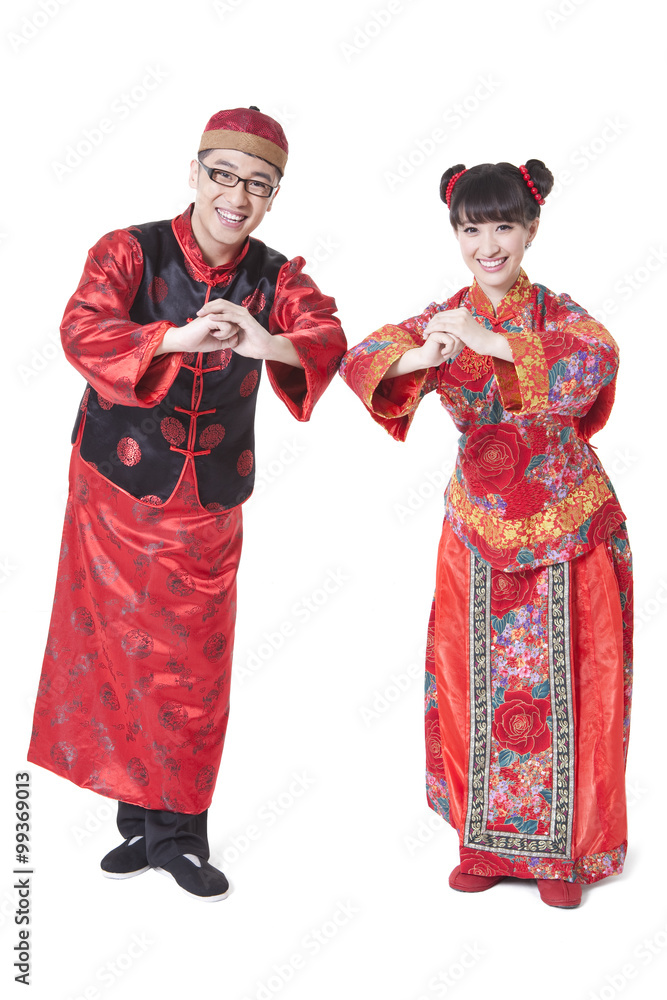 Young couple in traditional Chinese clothing greeting for Chinese New Year Young couple in traditional Chinese clothing greeting for Chinese New Year