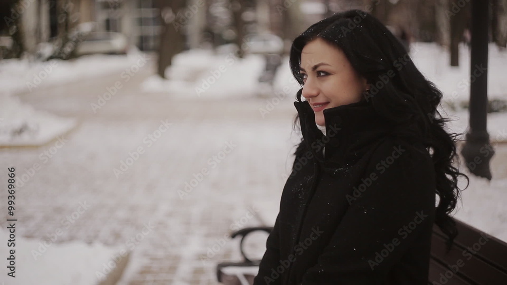 woman in winter park sitting on the bench woman in winter park sitting on the bench