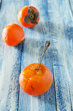 Ripe sweet persimmons on wooden table