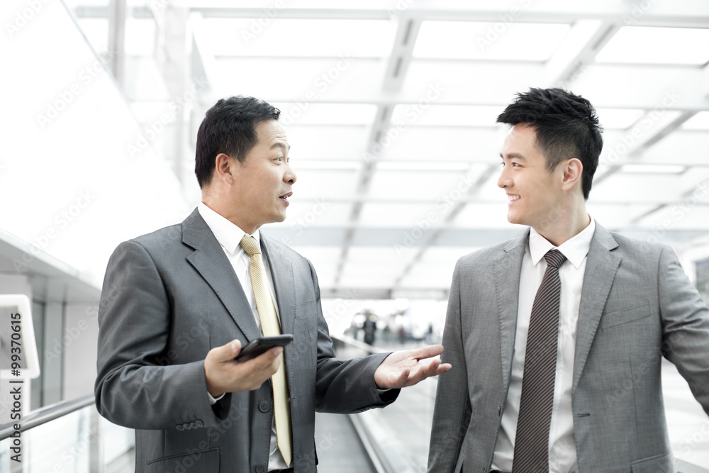 Confident business people on airport escalator Confident business people on airport escalator