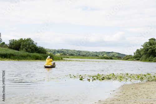 In summer, the woman fisherwoman boat floats on the river with a