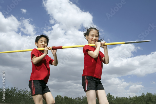 Children Holding A Large Javelin