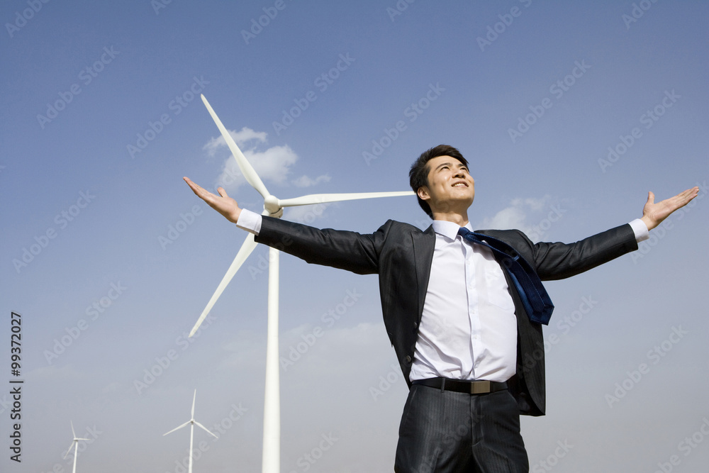 Businessman in front of wind turbine Businessman in front of wind turbine
