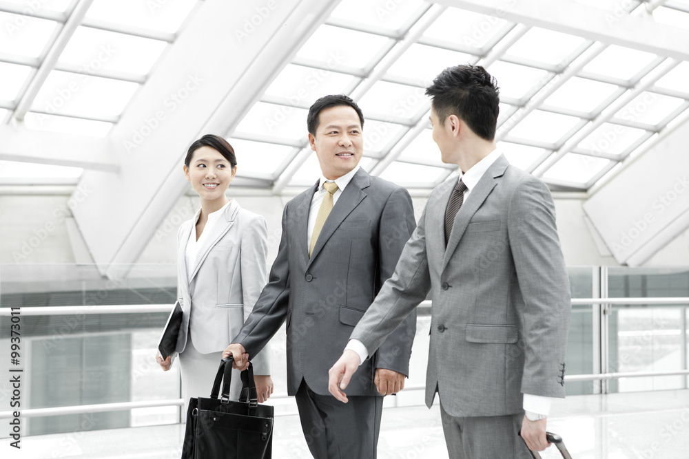 Business partners on the move in airport lobby Business partners on the move in airport lobby