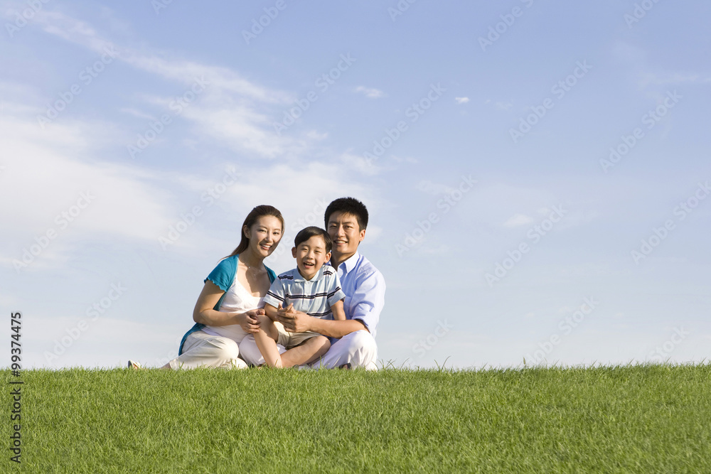 Family of three sitting on the grass Family of three sitting on the grass