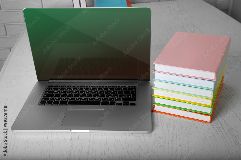Stack of books with laptop on table close up Stack of books with laptop on table close up
