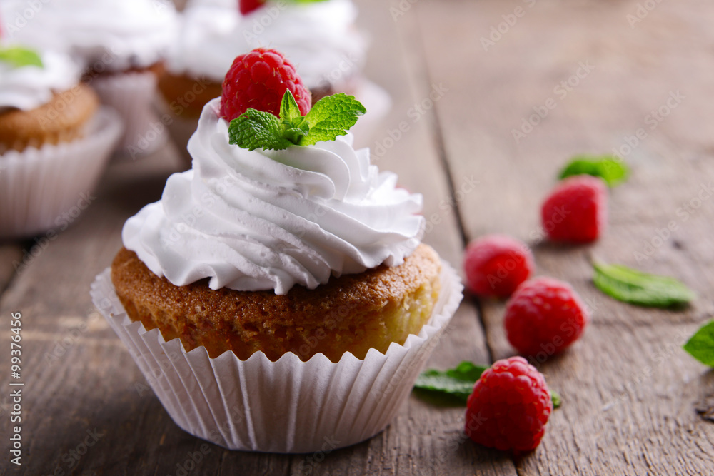 Delicious cupcakes with berries and fresh mint on wooden table close up Delicious cupcakes with berries and fresh mint on wooden table close up