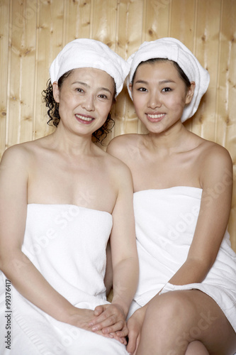 Women Sitting In Sauna Wearing Towels