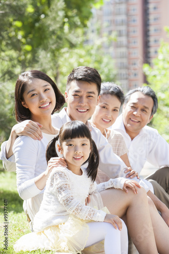 Happy family sitting in a row outdoors