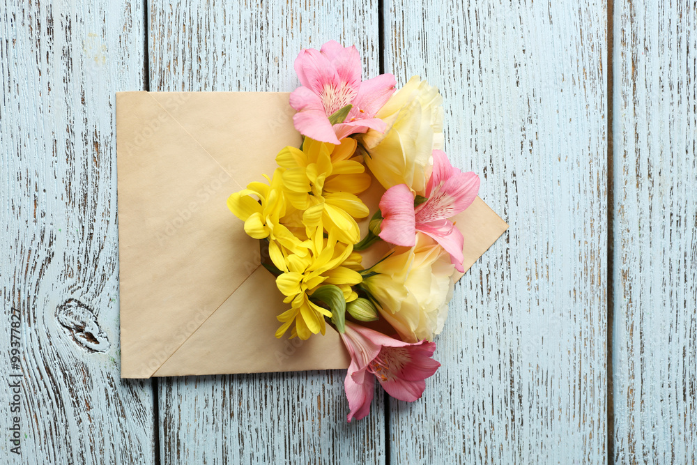 Fresh bouquet of flowers in envelope on wooden background Fresh bouquet of flowers in envelope on wooden background