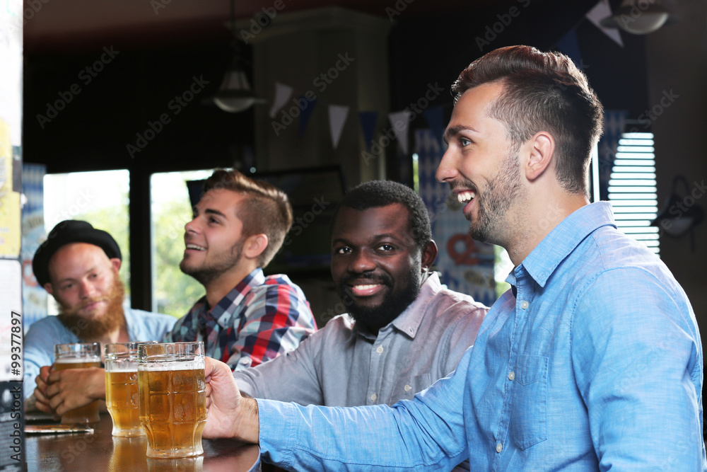 Young men drinking beer in pub Young men drinking beer in pub