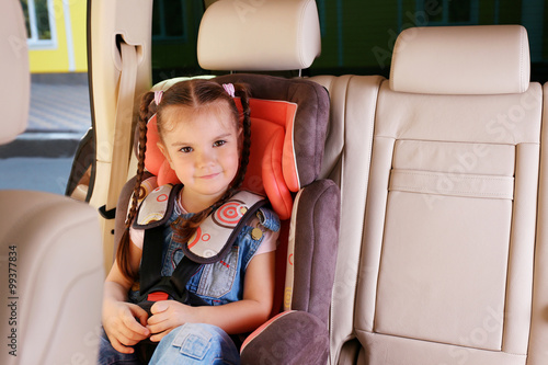 Cute little girl sitting in...