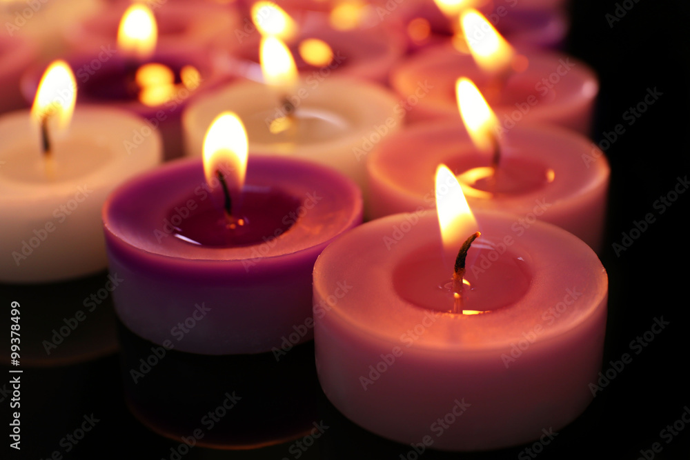 Many burning small candles on dark background, close-up Many burning small candles on dark background, close-up