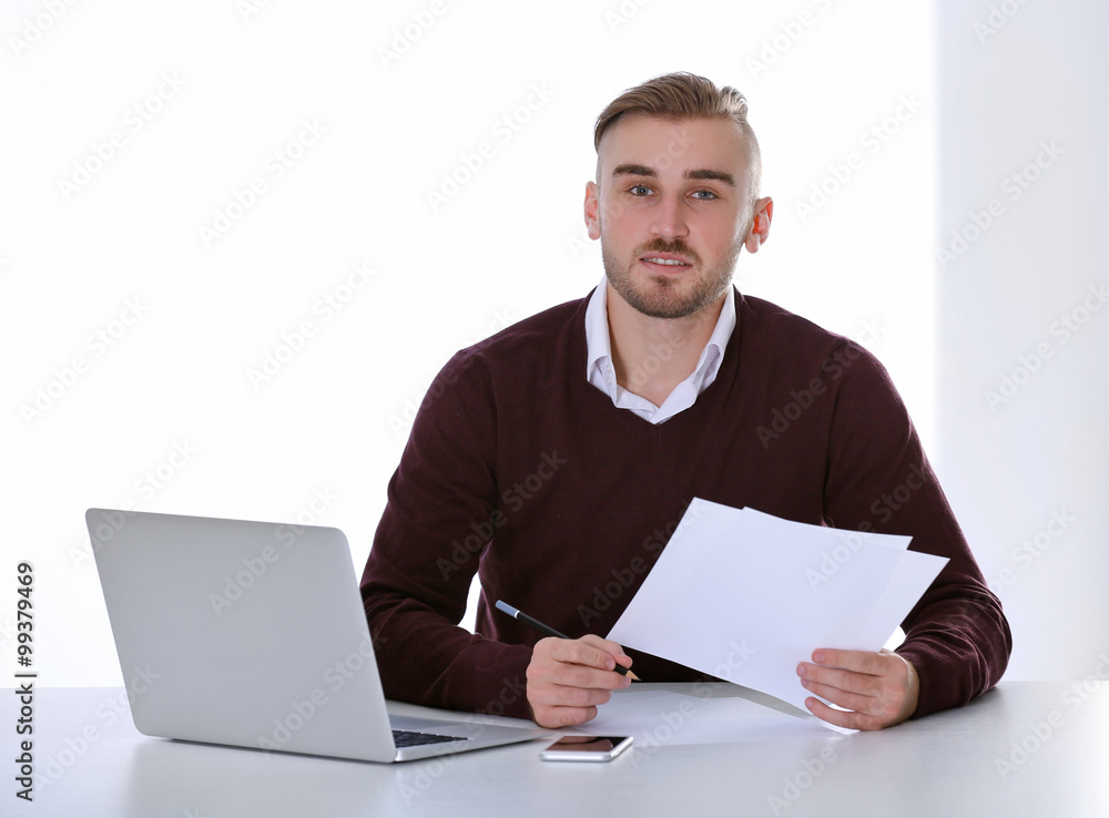 Businessman working with laptop on bright background Businessman working with laptop on bright background