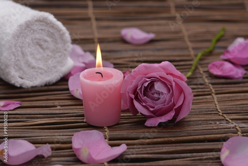 Pink rose with two candle and petals on mat