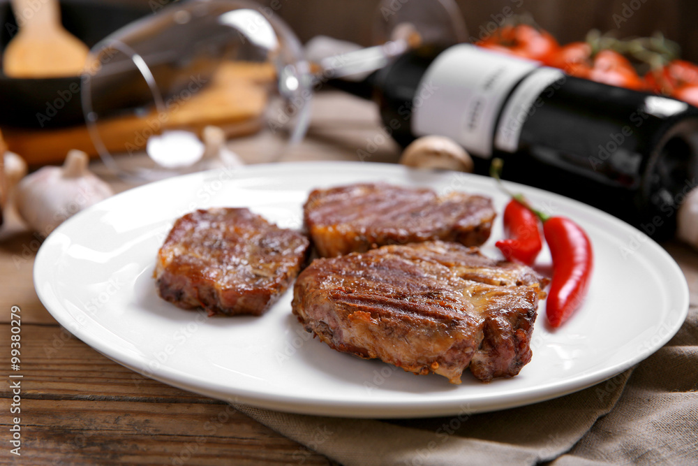 Roasted beef fillet on plate, on wooden background Roasted beef fillet on plate, on wooden background