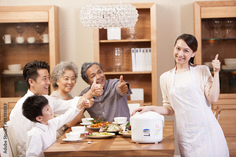 Happy family showing thumbs up at meal time