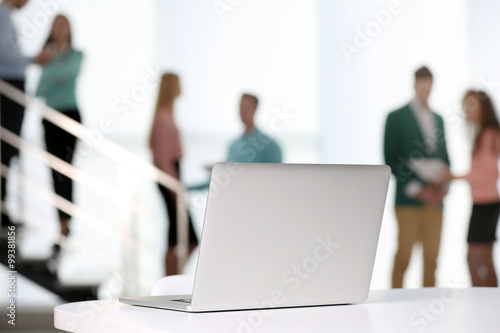 Laptop on the table in a conference room on blurred background
