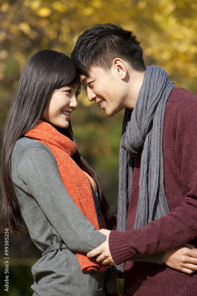 Fototapeta premium Sweet young couple in love face to face outdoors in autumn
