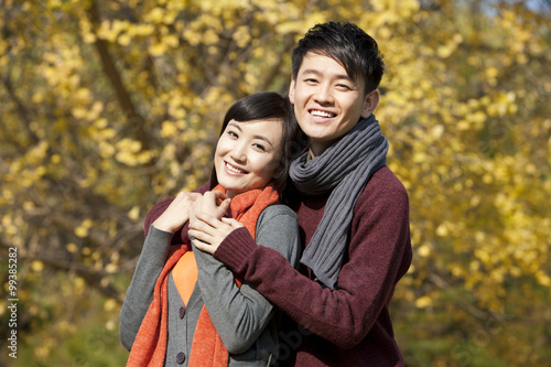 Happy young couple in love arm around outdoors in autumn