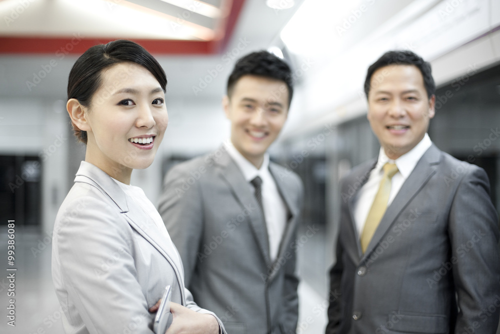 Business persons waiting for train on subway platform Business persons waiting for train on subway platform