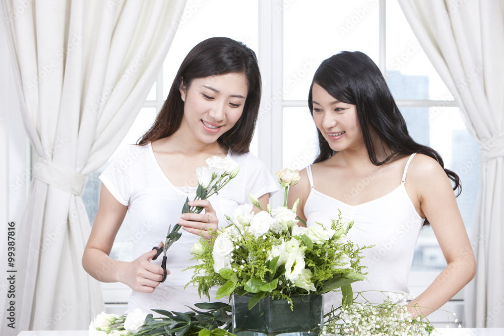 Best female friends arranging flowers together Best female friends arranging flowers together