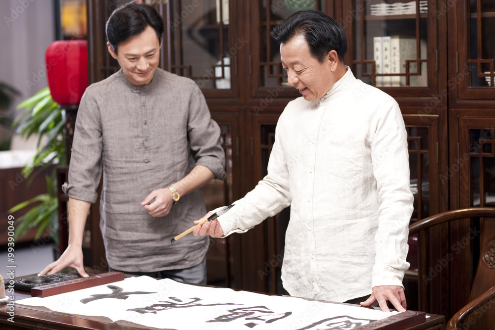Fototapeta premium Male friends practicing calligraphy in the study