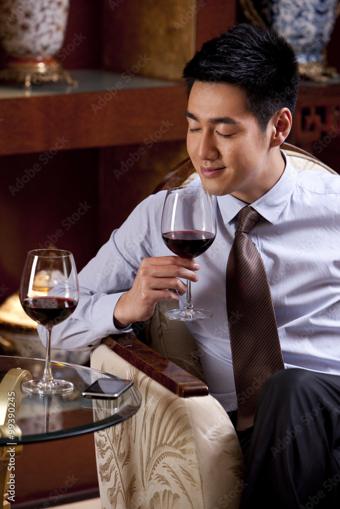 Young businessman enjoying wine in hotel Young businessman enjoying wine in hotel