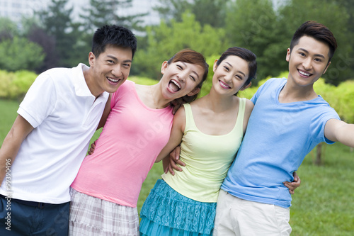 Cheerful young people arm around each other