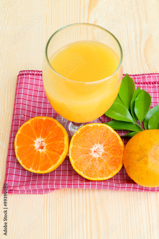 Glass of orange juice with orange slice on soft wooden background Glass of orange juice with orange slice on soft wooden background